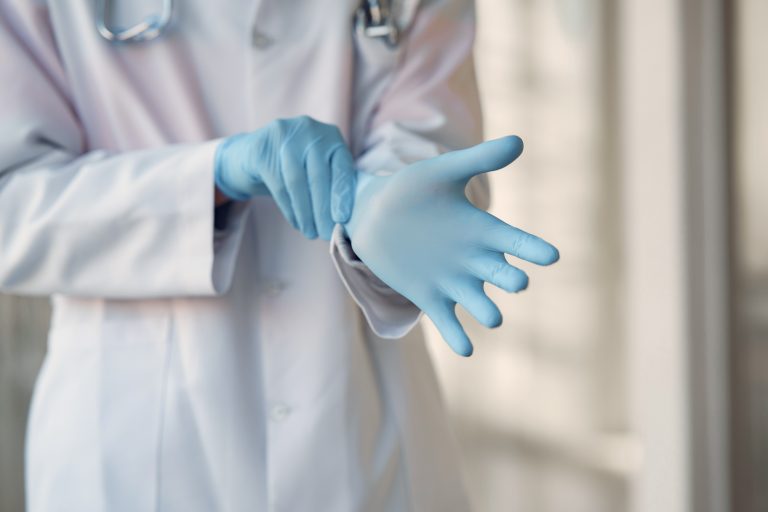 Person wearing blue sterile gloves